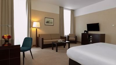 Executive Room with bed, sofa, desk, TV, and soft lighting at Polonia Palace Hotel