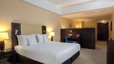 Junior Suite with a king bed, nightstands, lamps, and a desk area at Polonia Palace Hotel