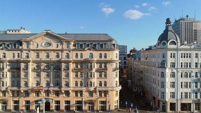 Aerial view of Polonia Palace Hotel facade with neo-classical architecture on a sunny day